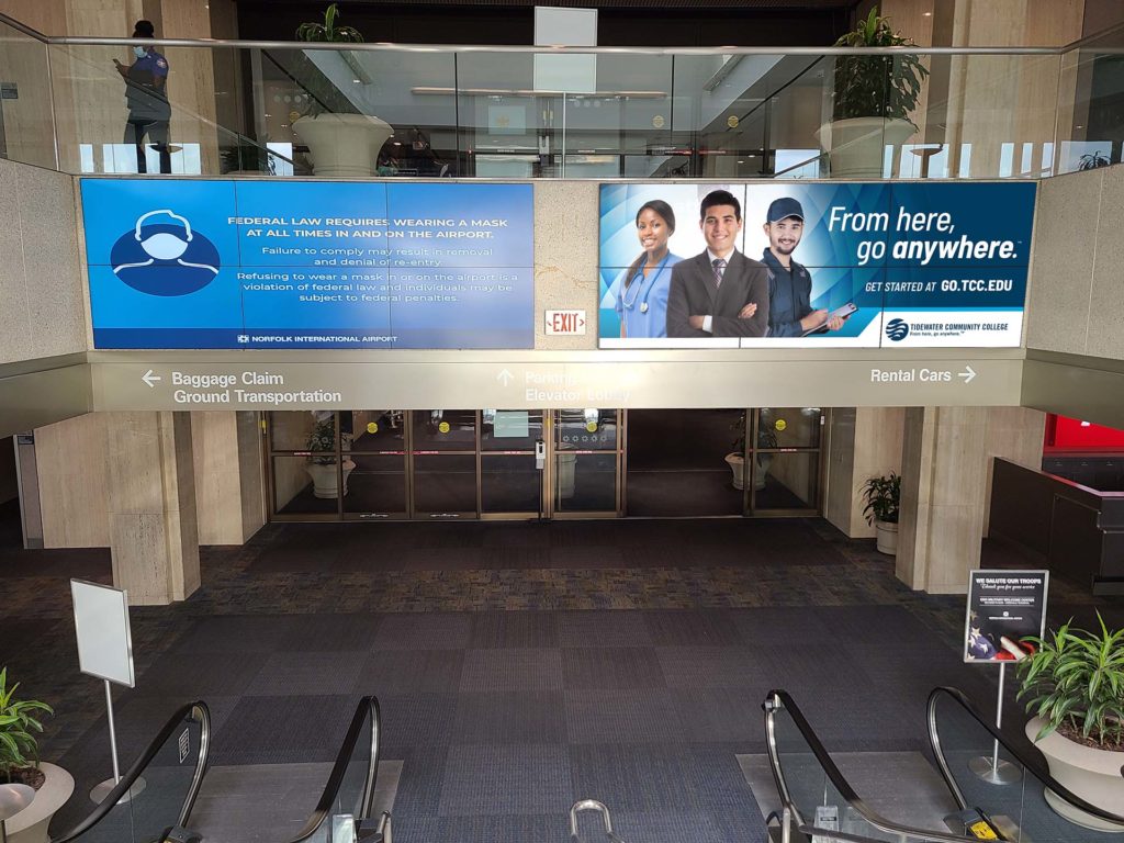 Digital billboard display over the descending escalators.